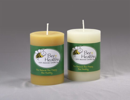 Two 3"x6" Twisted Octagonal Pillar - White beeswax candles with labels on them.