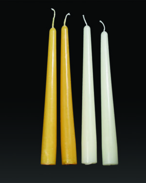 Four taper candles in white and yellow.