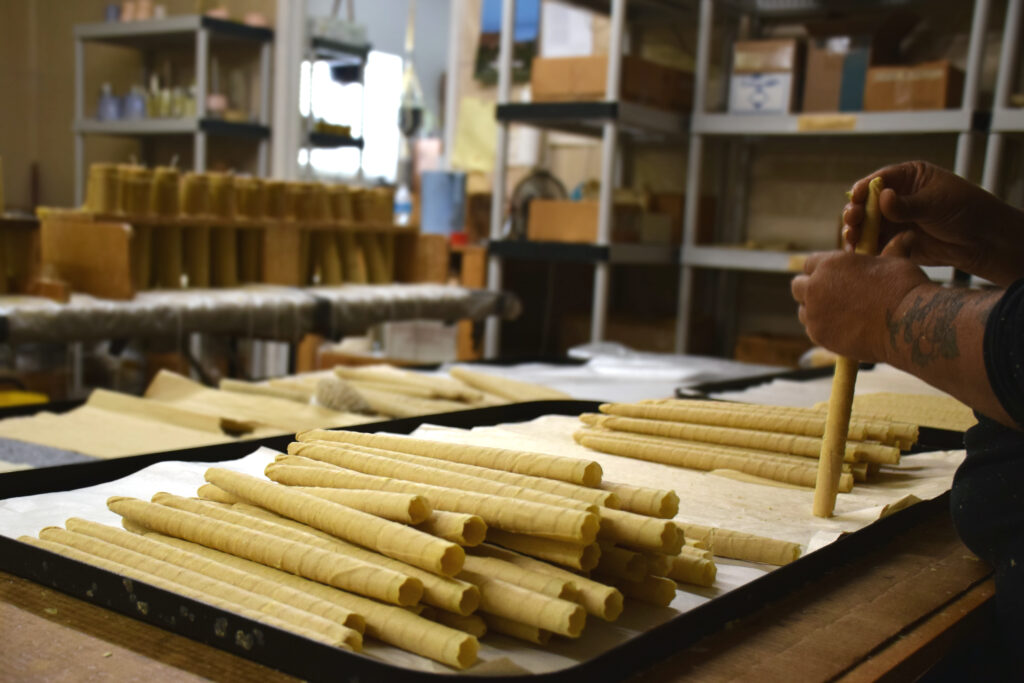 A person making rolled beeswax candles.