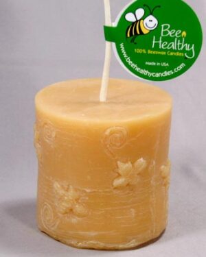 Beeswax candle with floral design.