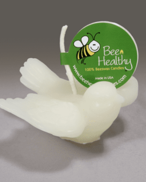 White dove-shaped beeswax candle with label.