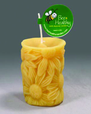 Yellow beeswax candle with floral design.