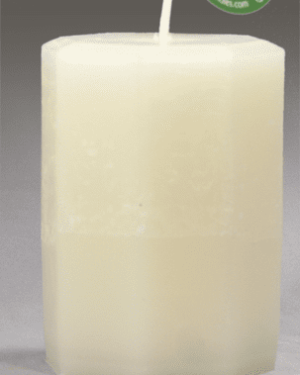 White pillar candle on a white surface.