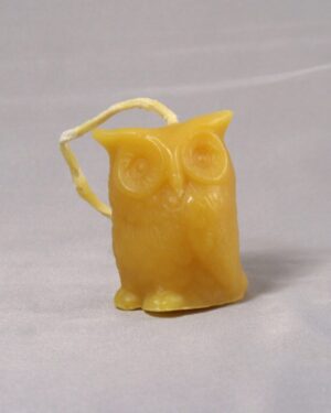 Yellow beeswax owl candle with string.