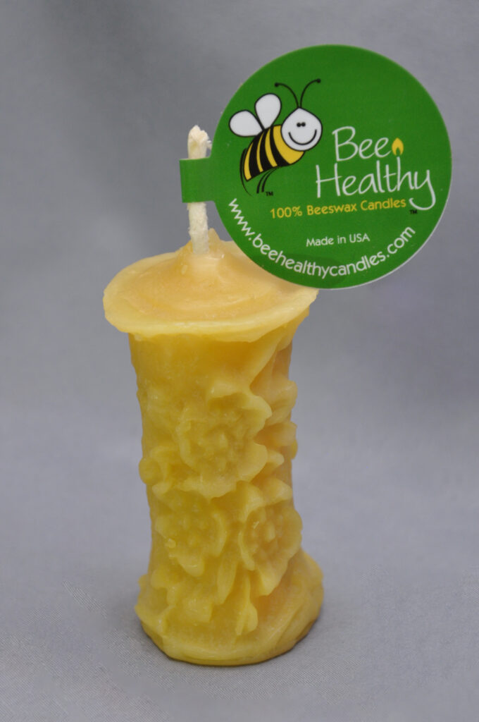 Yellow beeswax candle with bee design.