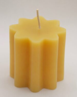 Yellow star-shaped candle with wick.