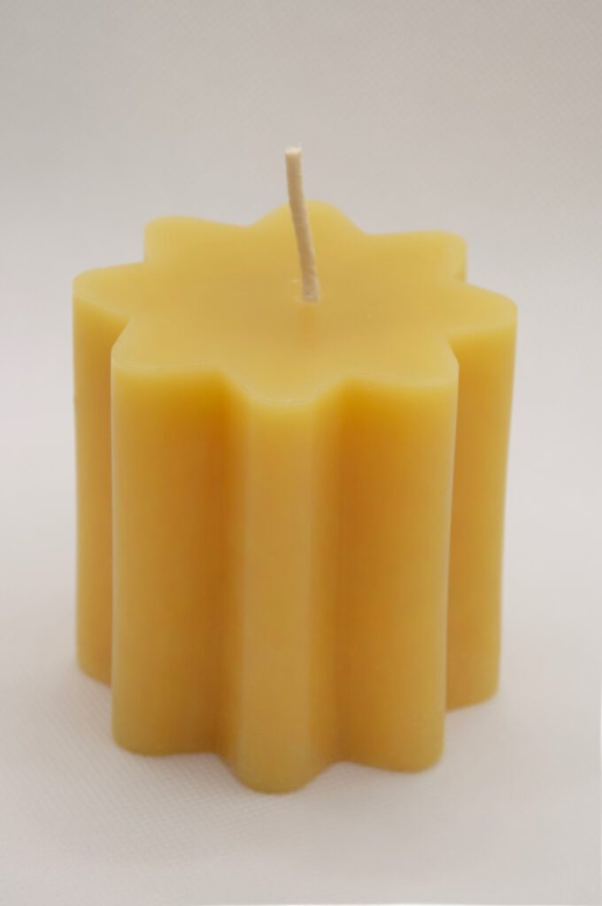 Yellow star-shaped candle with wick.