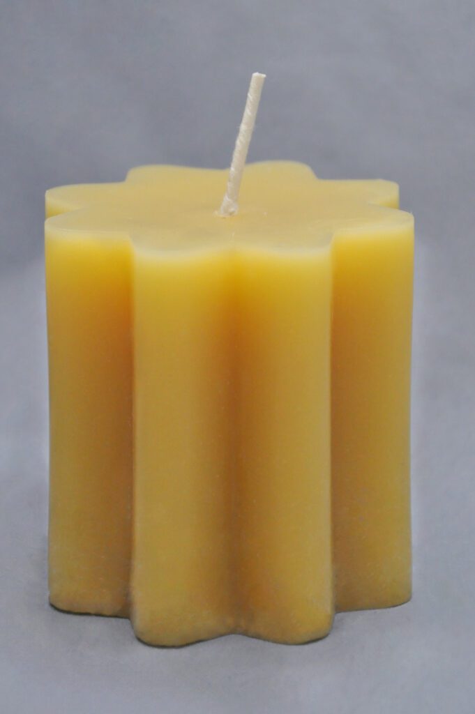 Yellow star-shaped candle with wick.