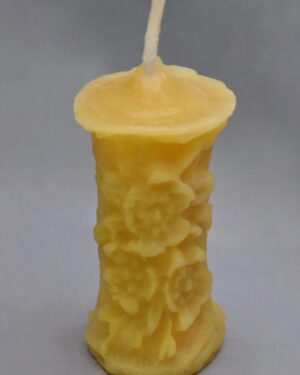 Yellow floral beeswax candle with wick.