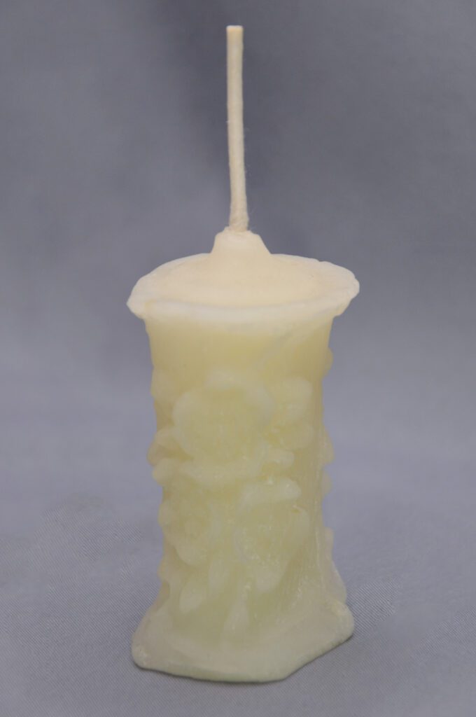 White pillar candle with a wick.